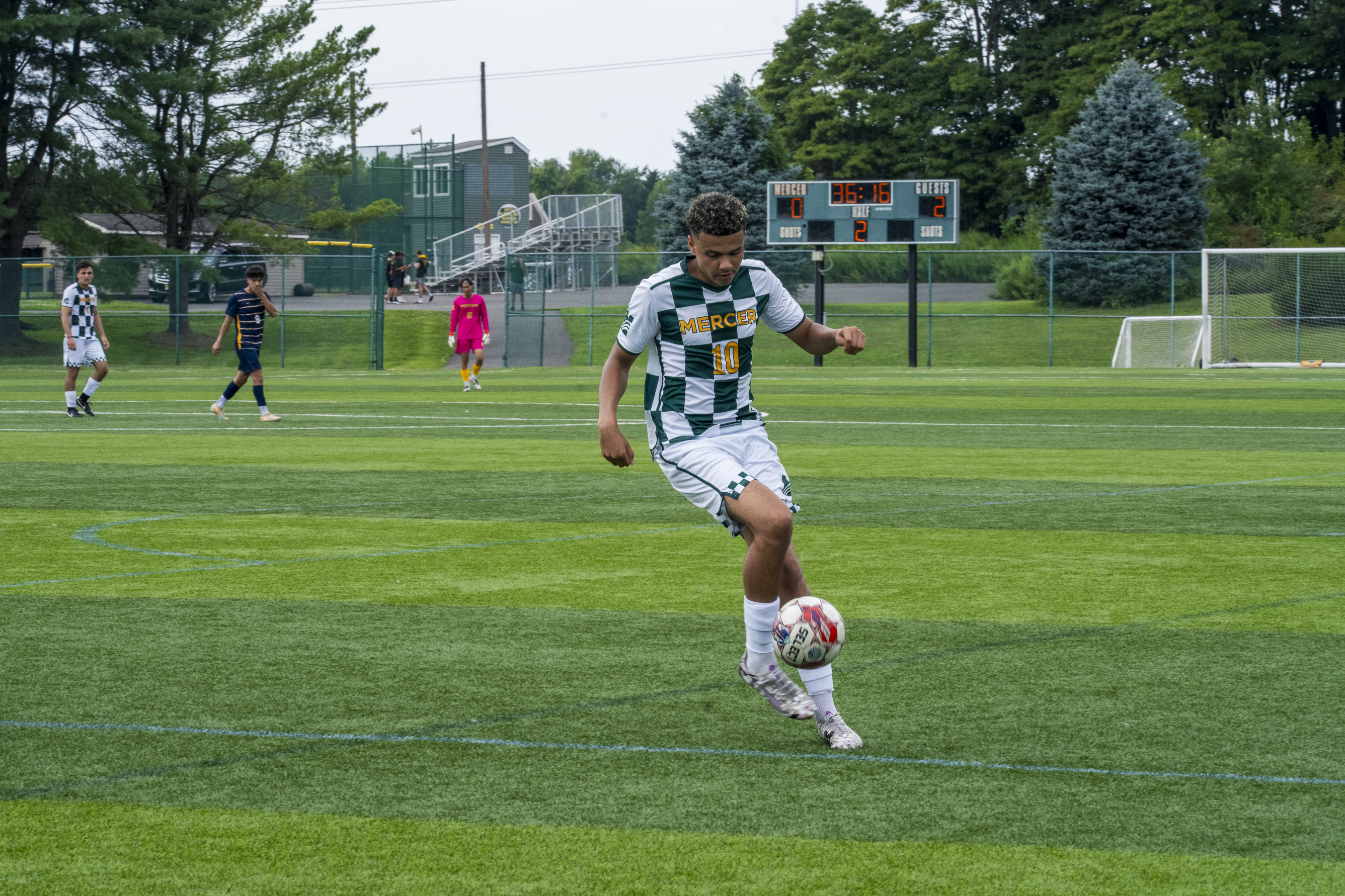 MCCC Men's Soccer Player Dribbling Ball on Field 